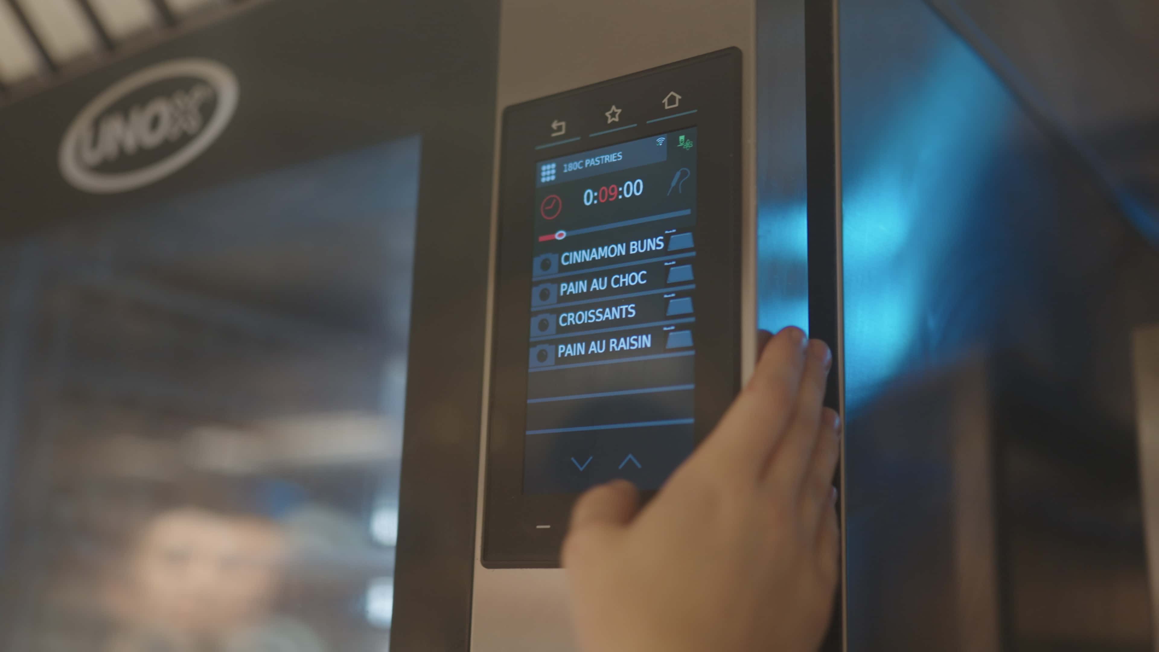 chef interactuando con el panel del horno mixto bakertop para pastelerías